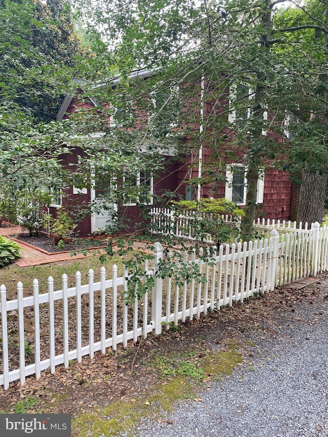 view of property hidden behind natural elements featuring a fenced front yard