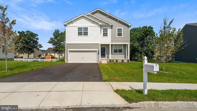 view of front of property featuring a garage, driveway, and a front lawn