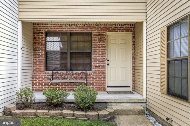 doorway to property with brick siding