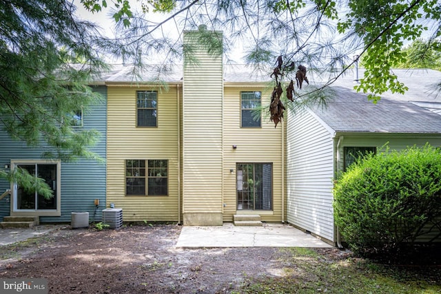 rear view of house featuring cooling unit, a patio area, a chimney, and entry steps