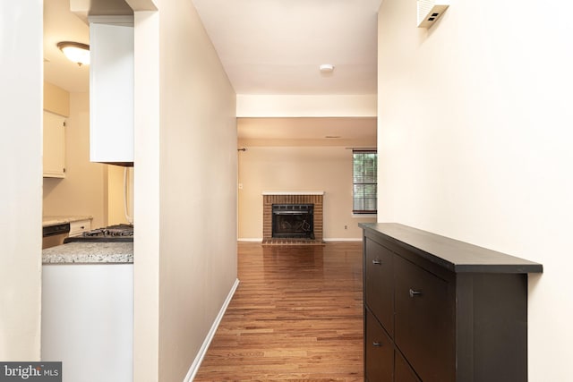 corridor with baseboards and light wood-style floors