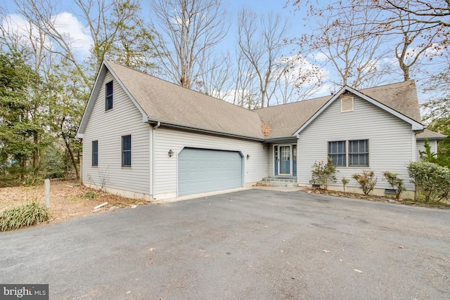 view of front of home with aphalt driveway, a garage, and roof with shingles