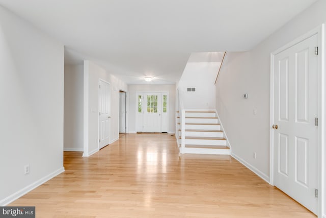 foyer with visible vents, light wood-style flooring, stairs, and baseboards