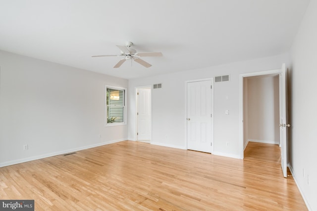 spare room featuring a ceiling fan, light wood-style floors, and visible vents