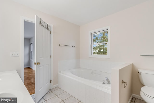 full bath featuring tile patterned floors, toilet, a bath, and a sink