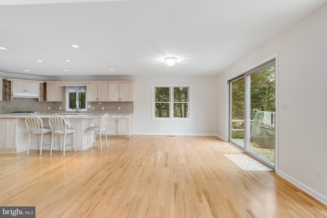 unfurnished living room featuring recessed lighting, light wood-style flooring, and baseboards