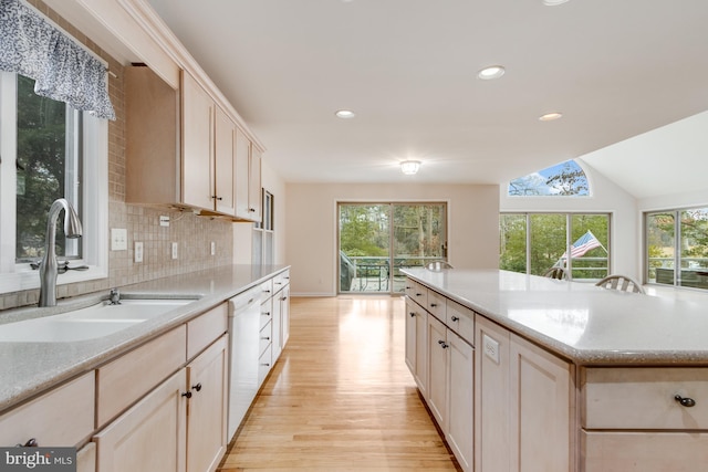 kitchen with a sink, decorative backsplash, dishwasher, and a wealth of natural light