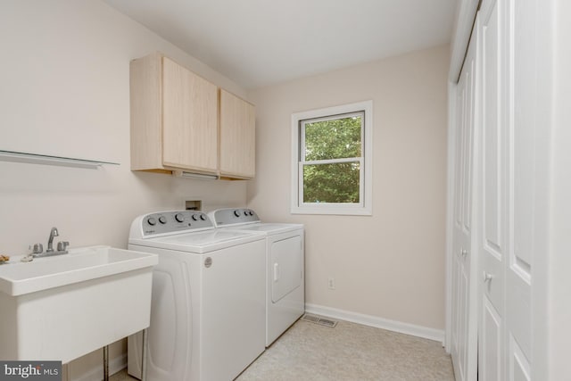 laundry room with washer and clothes dryer, cabinet space, baseboards, and a sink