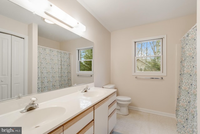 bathroom with a sink, baseboards, and a wealth of natural light