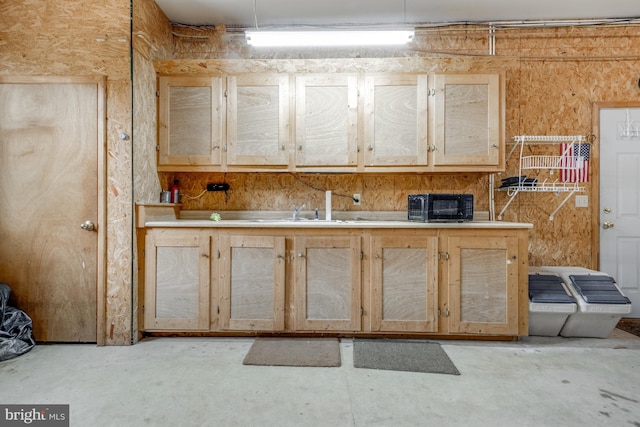 kitchen featuring light brown cabinets, a toaster, a sink, light countertops, and unfinished concrete flooring