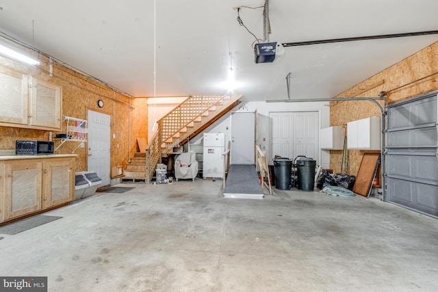 garage with a garage door opener and freestanding refrigerator