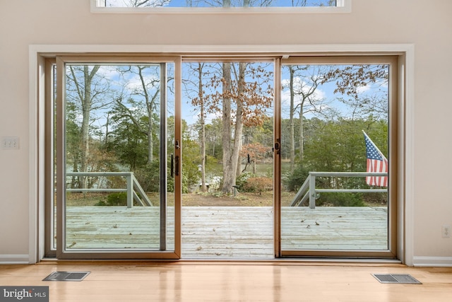 doorway with visible vents, baseboards, and wood finished floors