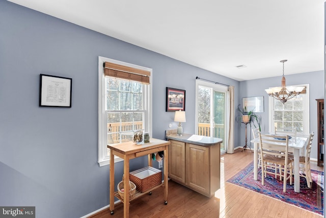 office featuring a notable chandelier, light wood-style flooring, visible vents, and baseboards