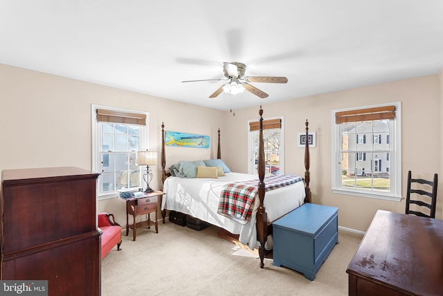 bedroom with light carpet, baseboards, and a ceiling fan