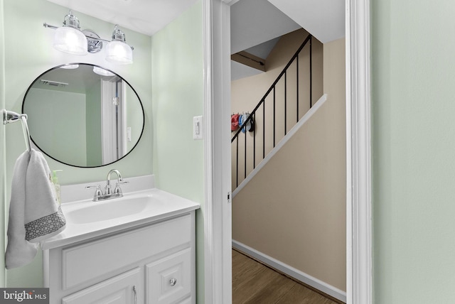 bathroom featuring visible vents, vanity, baseboards, and wood finished floors