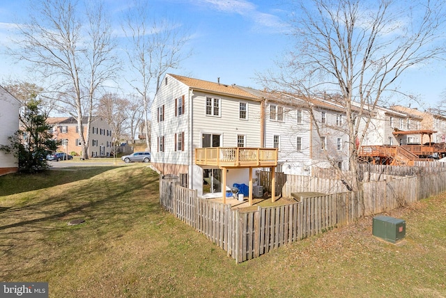 rear view of house with a deck, a yard, fence private yard, and a residential view