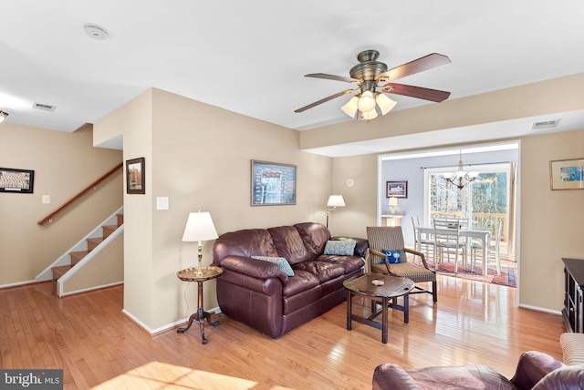 living area with stairway, light wood-style floors, and visible vents