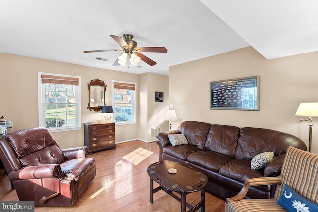 living room with visible vents, baseboards, wood finished floors, and a ceiling fan