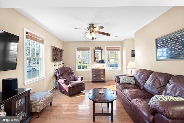 living room with plenty of natural light, wood finished floors, baseboards, and ceiling fan