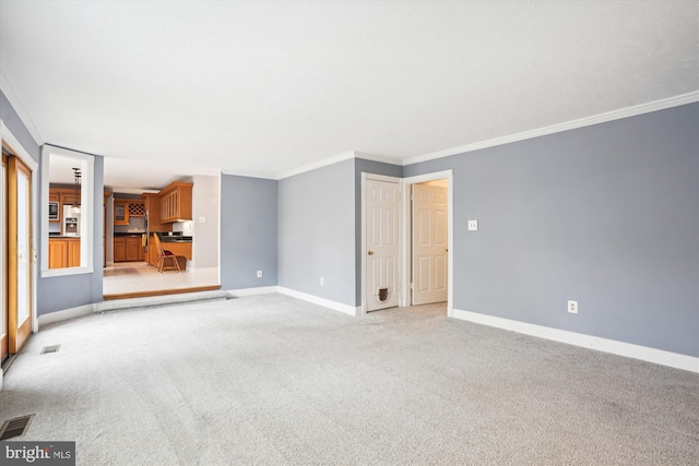 unfurnished living room featuring baseboards, light carpet, visible vents, and ornamental molding