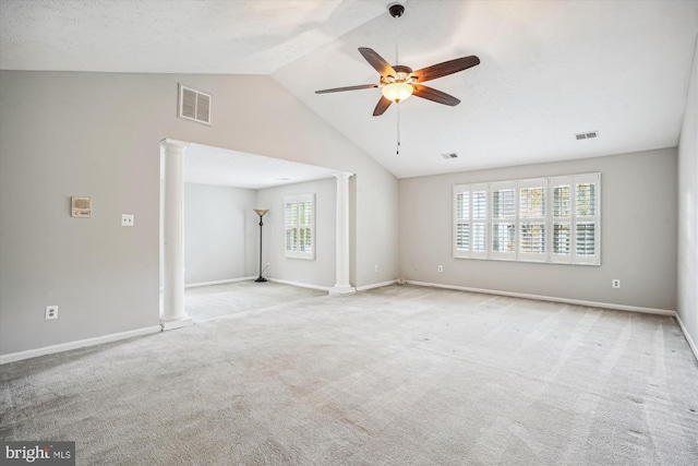 carpeted spare room with ceiling fan, baseboards, lofted ceiling, visible vents, and ornate columns