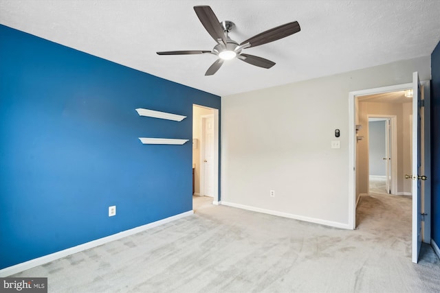 unfurnished bedroom featuring carpet floors, a textured ceiling, baseboards, and ceiling fan
