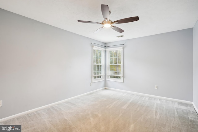 carpeted empty room with ceiling fan, baseboards, and visible vents