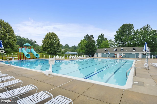 pool featuring a water slide, fence, playground community, and a patio