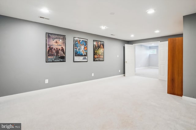 finished below grade area with light colored carpet, baseboards, visible vents, and recessed lighting