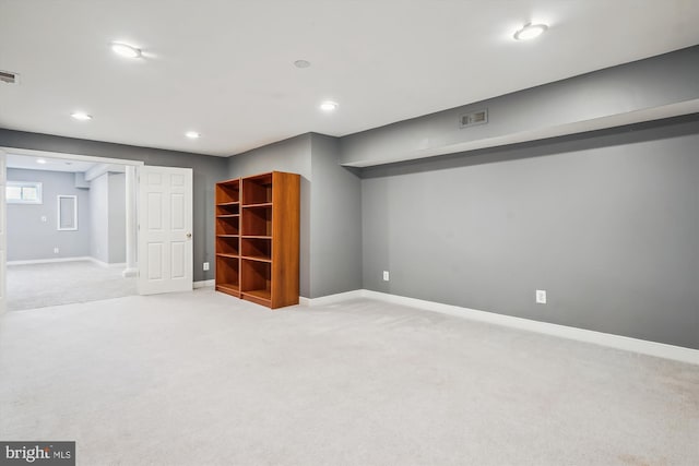 below grade area featuring baseboards, light carpet, visible vents, and recessed lighting