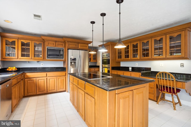 kitchen featuring brown cabinetry, a kitchen island, glass insert cabinets, and black appliances