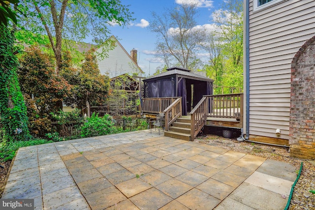 view of patio featuring a wooden deck and a gazebo