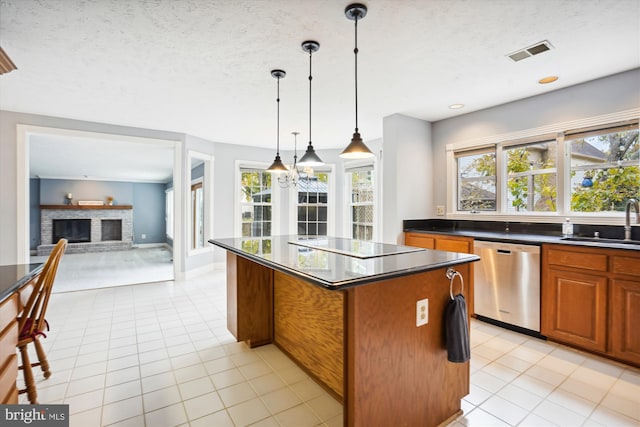kitchen with black electric cooktop, stainless steel dishwasher, a sink, visible vents, and a kitchen island