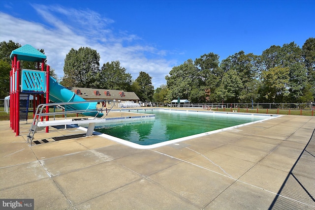 pool with fence, playground community, and a patio
