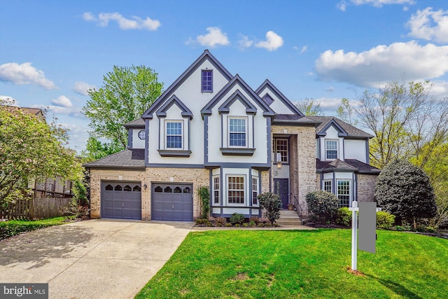view of front of property featuring a front lawn, concrete driveway, fence, brick siding, and stucco siding