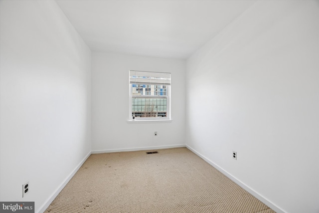 unfurnished room with carpet flooring, baseboards, and visible vents