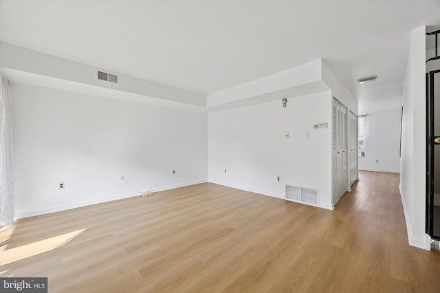 spare room featuring visible vents, light wood-style flooring, and baseboards