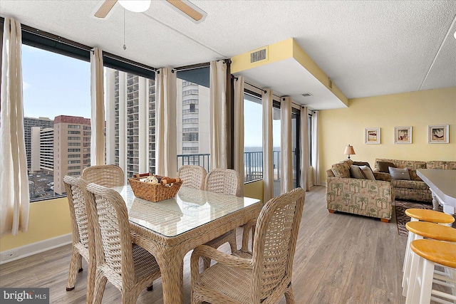 dining area featuring light wood-style flooring, baseboards, visible vents, and ceiling fan