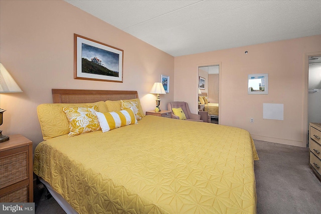 carpeted bedroom featuring a textured ceiling and baseboards