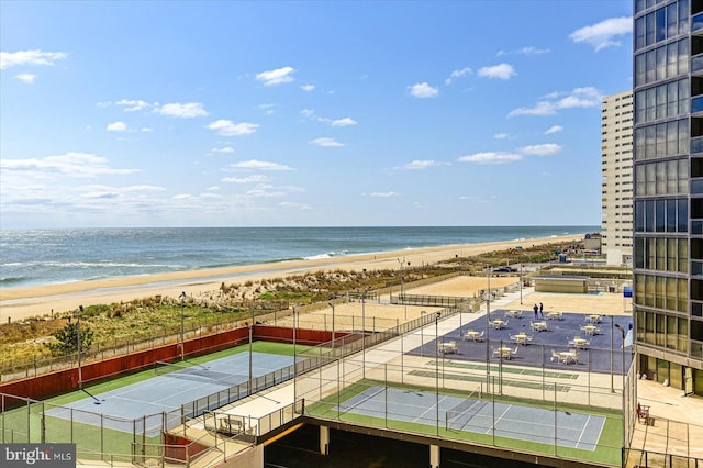 view of water feature featuring a view of the beach and fence