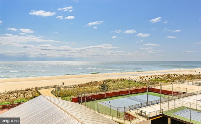 property view of water with fence and a beach view