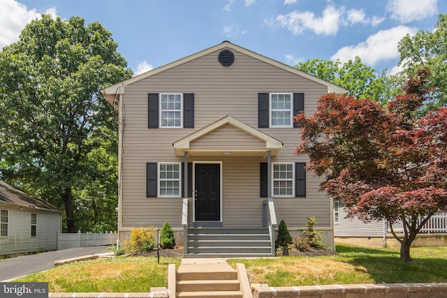 view of front of house with a front yard and fence