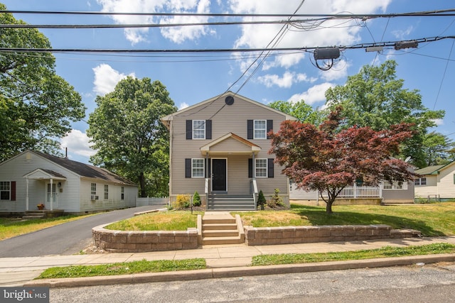 traditional-style home featuring aphalt driveway and a front lawn