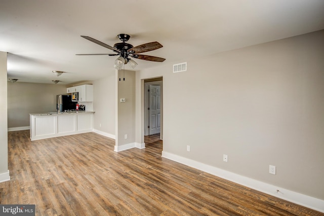 unfurnished living room featuring ceiling fan, baseboards, visible vents, and light wood-type flooring