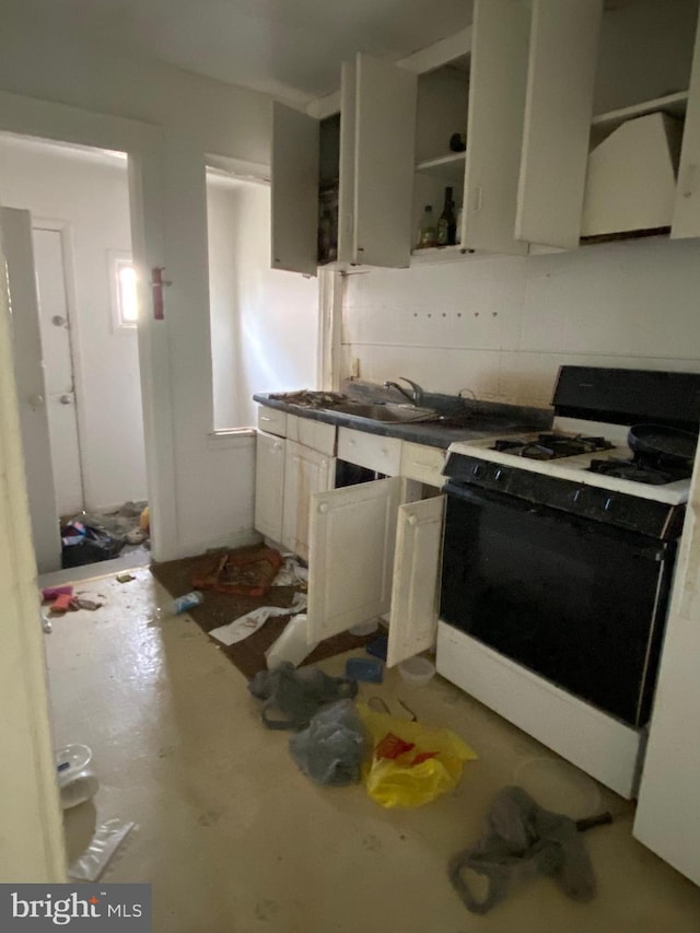 kitchen featuring open shelves, a sink, backsplash, white cabinets, and gas range