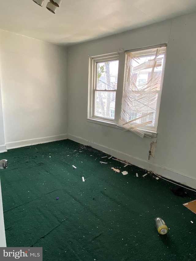 carpeted spare room with baseboards