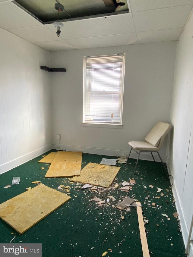 carpeted spare room featuring a paneled ceiling