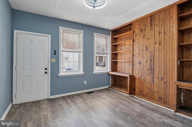 entrance foyer with visible vents, wood finished floors, and baseboards