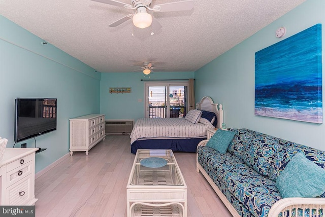 bedroom with a ceiling fan, access to outside, light wood-style floors, and a textured ceiling