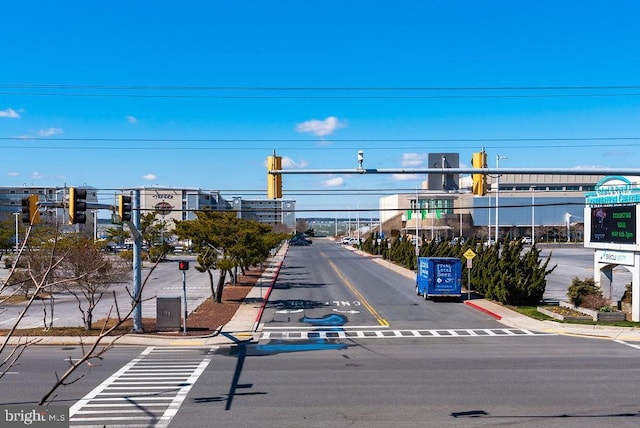 view of road with traffic signs, curbs, sidewalks, and traffic lights